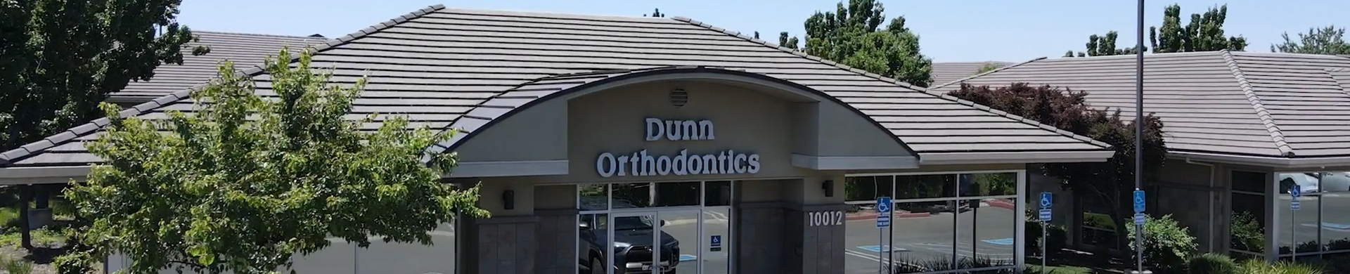 Dunn Orthodontics exterior storefront with entrance signage and landscaping, daytime view.